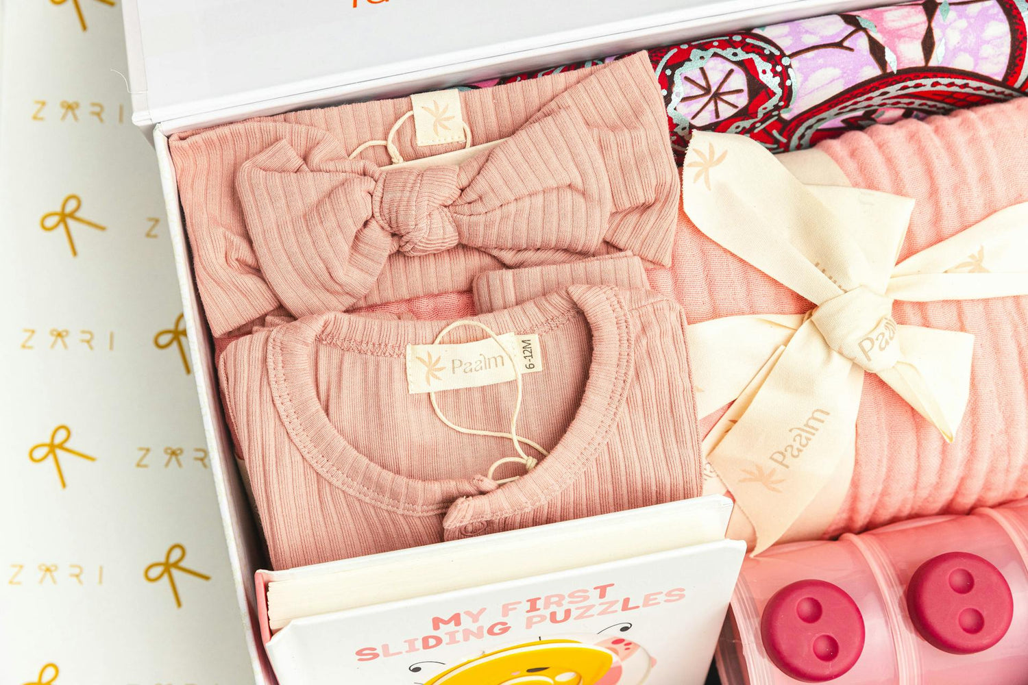 Gift box featuring pink ribbed baby clothing set with a matching headband, cozy newborn essentials, and baby gift ideas, perfect for baby showers and new parents.