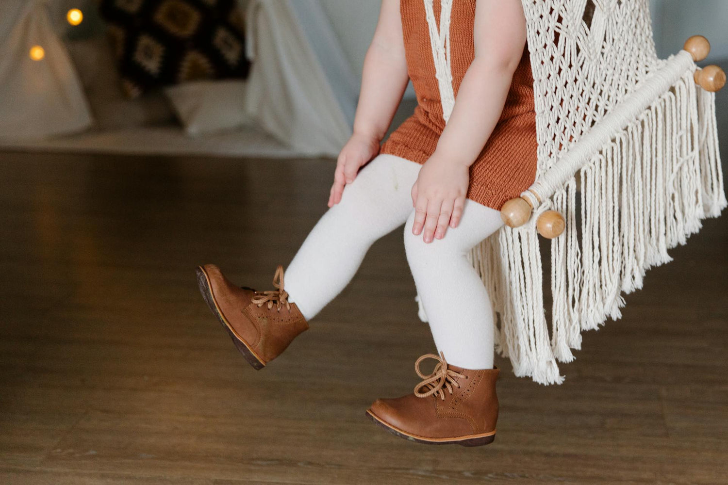 Toddler in a sleeveless knit top paired with white leggings and brown leather boots, trendy and durable toddler clothing for everyday wear, featuring breathable and comfortable kids' fashion.